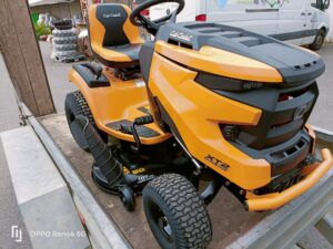 Tondeuse autoportée Cub Cadet XT2 Enduro Series avec coupe de 107 cm, chargée sur une remorque en bois.